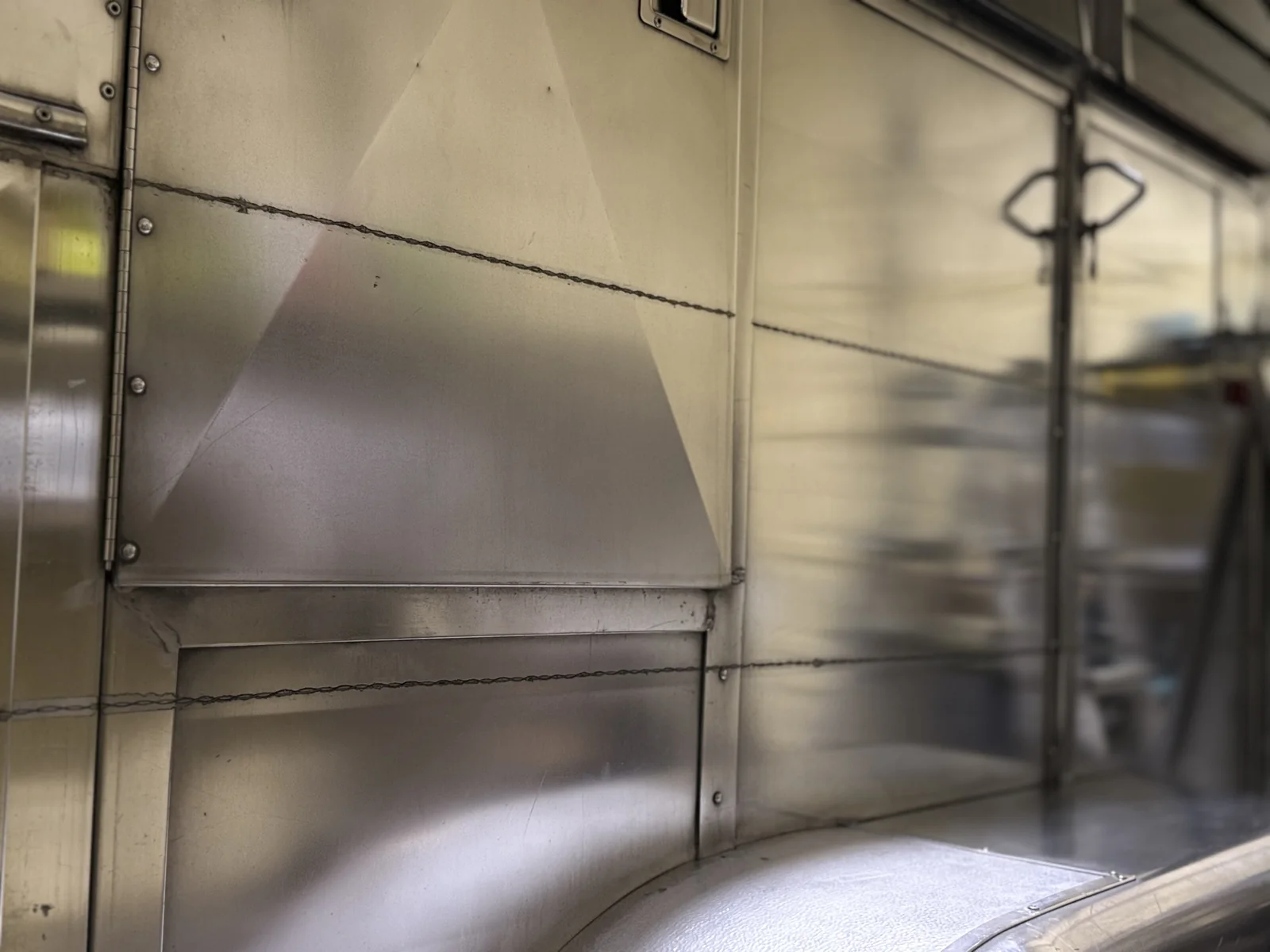 Close-up of polished aluminum trailer panels with sharp reflections