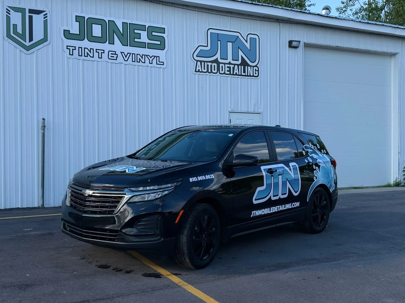 JTN Auto Detailing shop sign with a branded JTN Chevy Equinox mobile unit parked out front