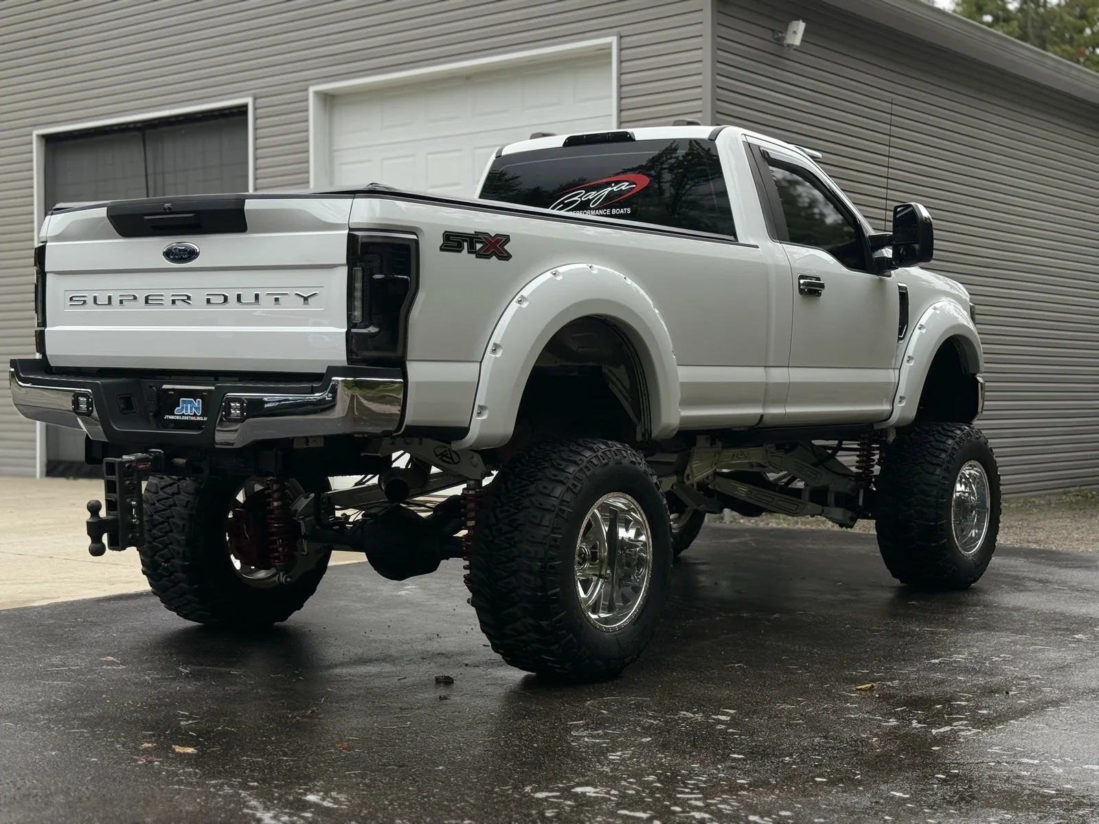 Lifted white Ford Super Duty pickup after a full exterior detail, rear three-quarter view