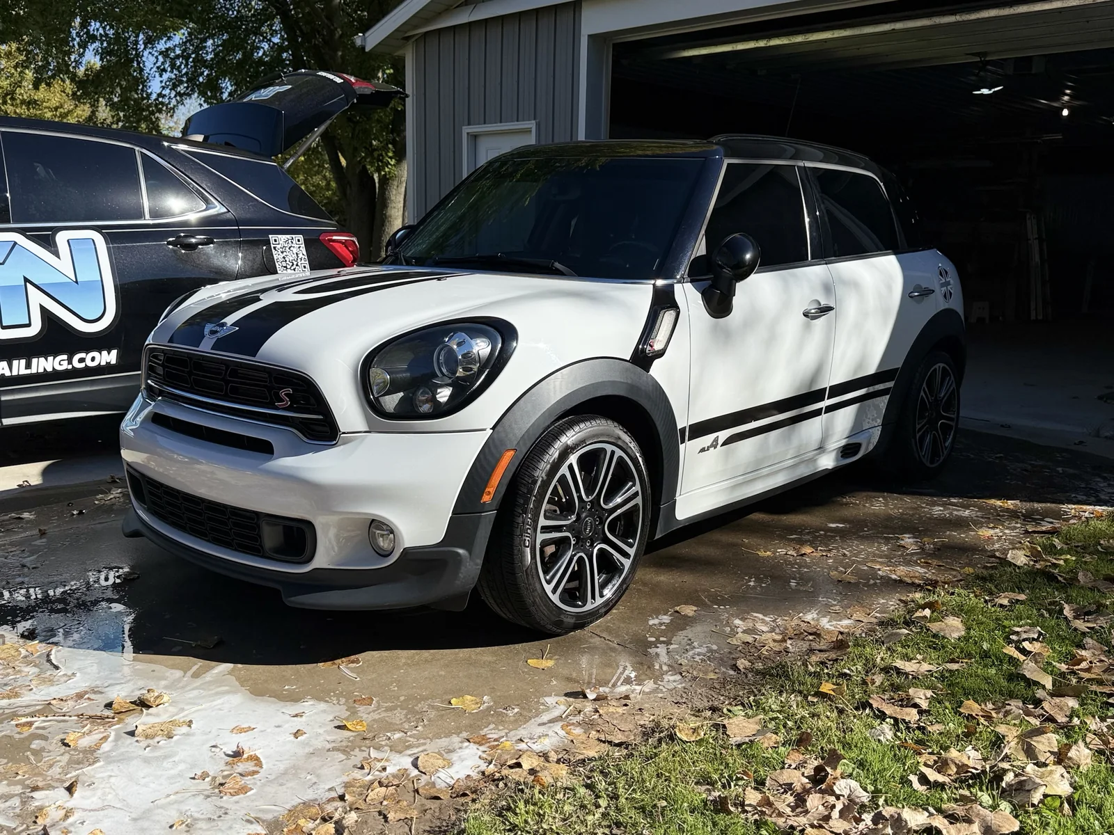 White Mini Cooper Countryman after a mobile detail, parked next to a JTN Mobile Detailing branded Chevy Equinox