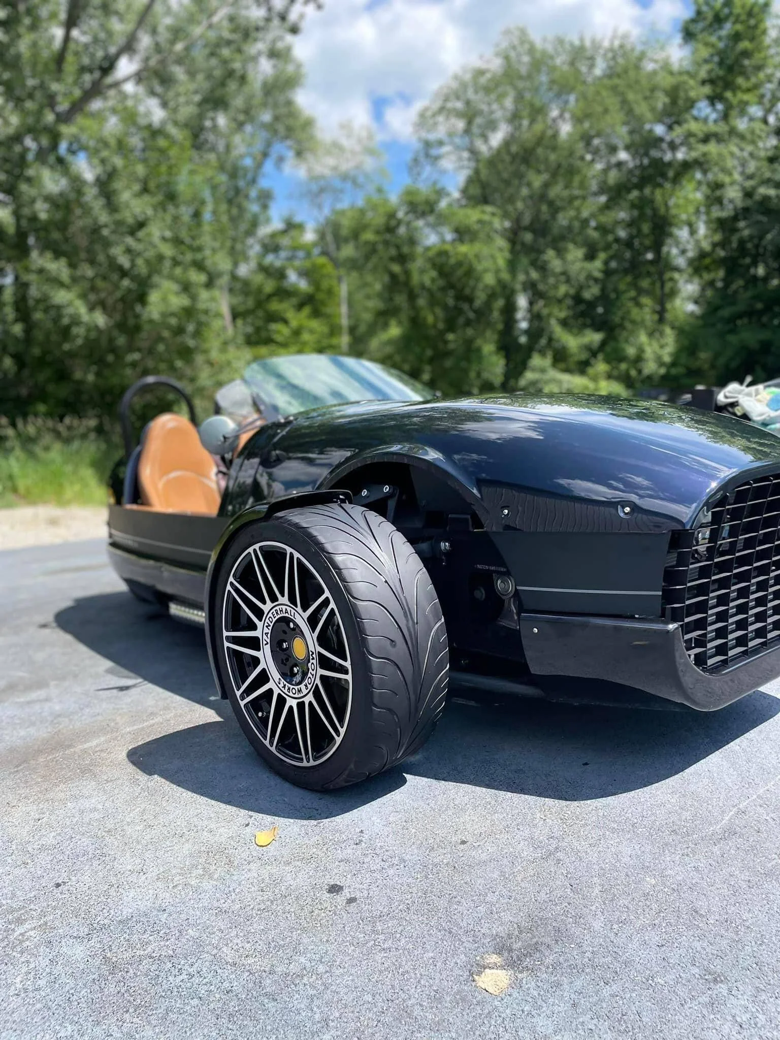 Black Vanderhall three-wheeler with tan leather seats after detailing
